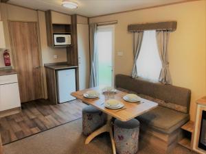 una pequeña sala de estar con mesa y sofá en Laurel Superior Holiday Home en Mablethorpe