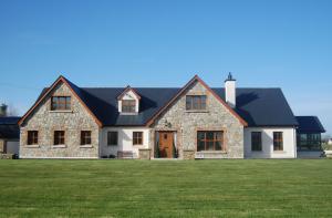 a large stone house with a black roof at Lissadell Lodge in Carney