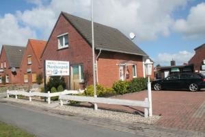 a building with a sign in front of a house at Hotel Nordseegruß in Norddeich