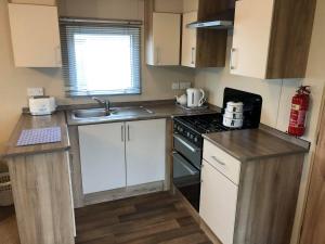 a small kitchen with a sink and a stove at Laurel Superior Holiday Home in Mablethorpe