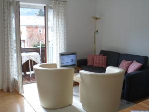 a living room with a couch and a table and chairs at Haus Auracher in Unterwössen