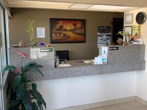 a reception counter in a office with a painting on the wall at Western Motel - Jesup in Jesup