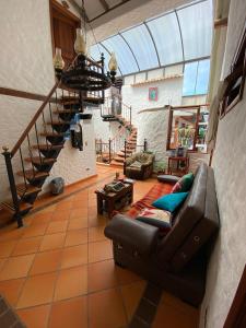 a living room with a couch and a staircase at Hotel - Hospedería Villa Palva in Villa de Leyva