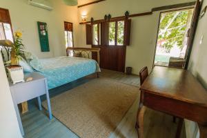 a bedroom with a bed and a desk and a table at Ocacocar - Milagres in São Miguel dos Milagres