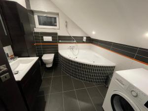 a bathroom with a tub and a toilet and a sink at Apartmány Diana in Dunajská Streda +61 photos
