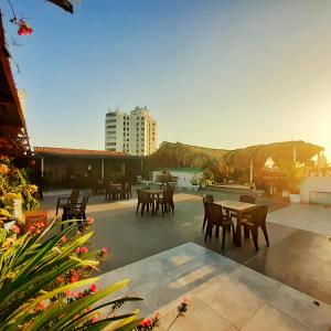 eine Terrasse mit Tischen und Stühlen und einem Pool in der Unterkunft Hotel Marie Real Cartagena in Cartagena de Indias