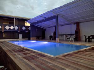una grande piscina blu con un tavolo su un patio di Pousada pesque park 2 a Boracéia