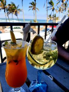 zwei Cocktails auf einem Tisch mit Blick auf den Strand in der Unterkunft Flight Inn in Margate
