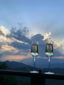 dos copas de vino sentadas en una cornisa con vistas en Chalés Sol e Lua, en Campos do Jordão