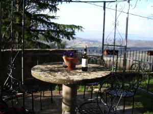una mesa con una botella de vino y flores. en Borgo Rapale, en Rapale