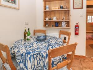a dining room with a blue and white table and chairs at Robyn Cottage in Budleigh Salterton