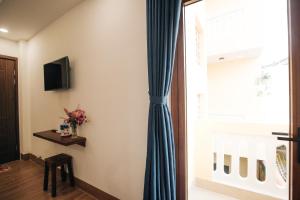 a room with a blue curtain and a window at THE VIEW HOMESTAY HỘI AN in Hoi An