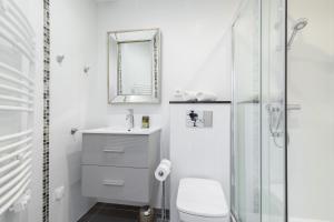 a white bathroom with a sink and a mirror at Cosy 1 Bdr near Garibaldi Square - Top Floor & AC in Nice