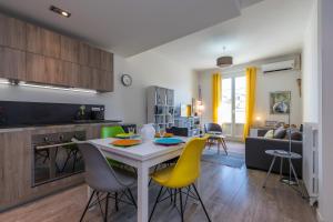 cocina y sala de estar con mesa y sillas en Cosy 2 Bdrs-Terrace near GaribaldiVieux NicePort en Niza