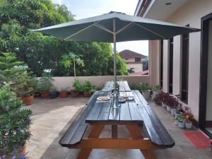 a picnic table with an umbrella on a patio at Lourdes Inn in Manila