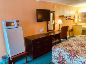 Pokój hotelowy z łóżkiem, biurkiem i telewizorem w obiekcie Gateway Inn w mieście Sullivan