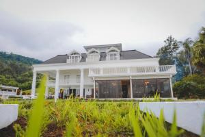 a large white house with a porch at Fogo Resort in Escazu