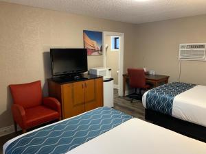 um quarto de hotel com um quarto com uma cama e uma televisão em Champlain Motor Inn em Pembroke