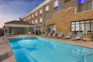 een zwembad voor een hotel bij Holiday Inn Express Hotel & Suites Merced, an IHG Hotel in Merced