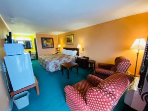 pokój hotelowy z łóżkiem i 2 krzesłami w obiekcie Gateway Inn w mieście Sullivan