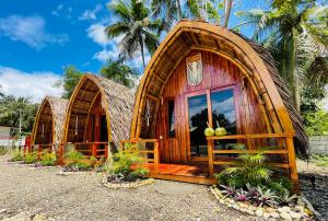 a group of huts in a resort with palm trees at MAAYONG HOSTEL in Moalboal