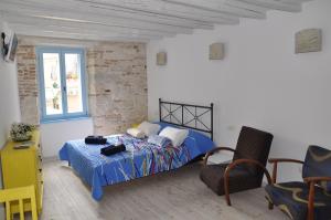 1 dormitorio con 1 cama y 1 silla en Studios Barbaro, en Rovinj