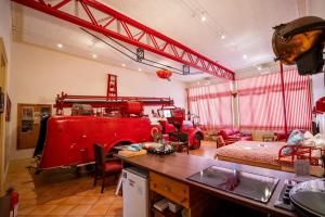 a living room with a red fire truck in it at Fire Station Inn in Adelaide