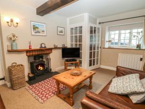 a living room with a couch and a fireplace at Robyn Cottage in Budleigh Salterton