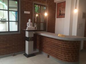 Una statua di una donna seduta sopra un muro di mattoni di Sea Breeze Guest house a Unawatuna Altre 144 foto