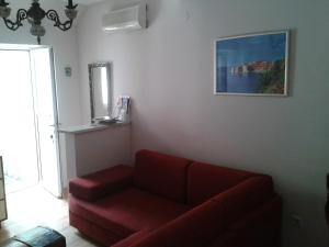 a living room with a red couch and a painting at Old Harbour City Center Apartment in Dubrovnik