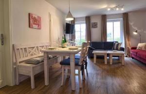 cocina y sala de estar con mesa y sillas en Stadtwohnung 1, en Wyk auf Föhr