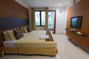 a bedroom with a large bed and a television at Safari Resort in Puncak