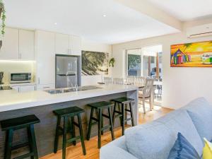 a kitchen and living room with a counter and chairs at Within Oceans Reach in Cape Woolamai +13 photos