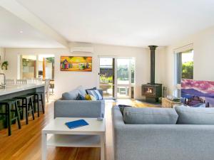 a living room with two couches and a stove at Within Oceans Reach in Cape Woolamai