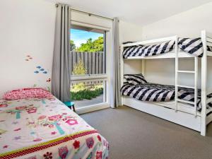 a bedroom with two bunk beds and a window at Within Oceans Reach in Cape Woolamai