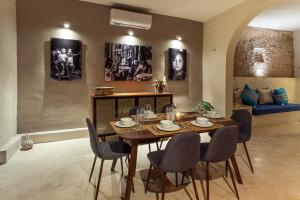 a dining room with a table and chairs and a couch at Luxury home in the heart of Merida in Mérida