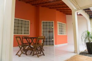 een tafel en stoelen in een kamer met een oranje muur bij Casa Linda in Santarém