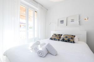 a white bedroom with a white bed with towels on it at Cosy 1 Bdr near Garibaldi Square - Top Floor & AC in Nice