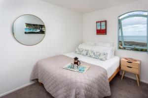 um quarto com uma cama com um espelho e uma mesa em Naxos - Med style castle, ocean views from every room! em Bowentown