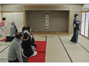 a group of people watching a man standing on a stage at Daichan Farm Guest House - Vacation STAY 19124v 