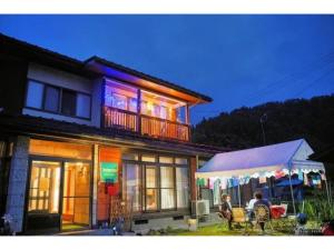 a house with a balcony and a table and chairs at Daichan Farm Guest House - Vacation STAY 19127v 