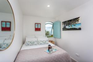 a bedroom with a bed and a mirror at Naxos - Med style castle, ocean views from every room! in Bowentown +42 photos