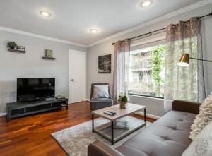 a living room with a couch and a tv at Amazing Midtown Atlanta Location by Piedmont Park Beltline Ponce City Market in Atlanta