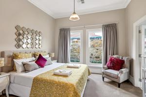 a bedroom with a bed and a chair and a window at Grandview Accommodation - The Elm Tree Apartments in Mount Barker