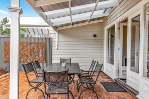 a patio with a table and chairs at Grandview Accommodation - The Elm Tree Apartments in Mount Barker