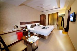 una camera d'albergo con letto e tavolo di HOTEL THE FORTUNE a Coimbatore