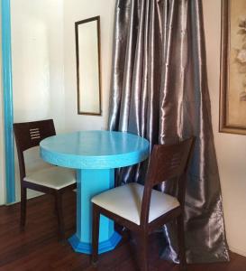 une table bleue avec deux chaises et un miroir dans l'établissement RedDoorz Near Gaisano Grand Cordova, à Cebu