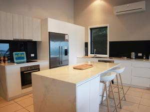 a kitchen with a large island with a refrigerator at Beachside Holiday Home with Stunning Seaviews in Avoca Beach