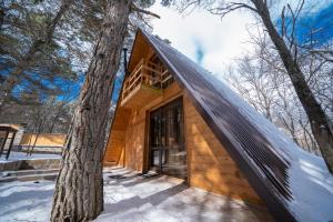 a wooden house in the woods with a tree at Woodland cottages in Tsaghkadzor