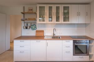 una cocina con armarios blancos y fregadero en Gästehaus Albero, en Lindau